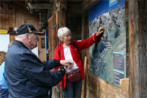 Eine Reisebegleiterin zeigt auf eine Landkarte