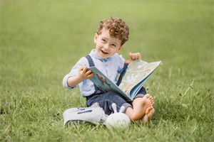 Kind im Gras mit einem Buch